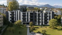 Modern apartment building with multiple floors, balconies, and a landscaped garden area.