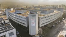 The image shows a large multi-story office building complex called Sternen Hof, with several interconnected buildings and a central tower structure. The buildings have flat roofs with greenery on top, likely serving as green roofs. The complex appears to