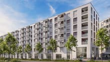 Multi-story apartment building with balconies, parking spaces, and landscaping in the front
