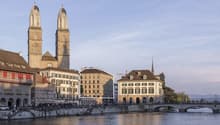 Modern building with medieval church in the background and a river in the foreground