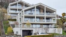 Modern 3-story house, white exterior, large glass windows, multiple balconies, garage, driveway, landscaped garden