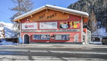 Red building with text 'SOT PLUNT', three signs for sport, perfume, and restaurant