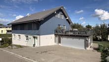 Ansicht mit Terrasse, Doppelgarage und Aussenfläche