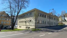 2 story beige building, 8 windows on each side, street in front
