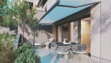Outdoor patio with a table and chairs, a lounge chair, and a retractable awning.