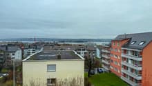 Aerial view of residential buildings with waterfront in the distance