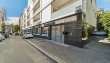 Modern apartment building, white exterior, glass doors, balconies, multiple windows, street view
