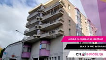 Apartment building, beige walls, purple balconies, multiple windows, street level entrance, parking