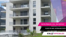 4-story apartment building with balconies, white exterior, and parking spaces on the ground level