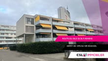 Multi-story commercial or residential building with yellow awnings and balconies, located on Route du Silo 26-36 in Renens. The building has a depot on the ground floor.