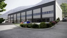 Industrial building, modern design, large windows, multiple parking spaces, landscaped entrance