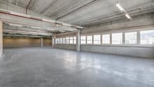 spacious room, concrete floor, high ceiling, large windows, metallic beams