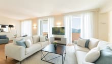 modern living room, two sofas, center table, TV, large windows, wooden floor
