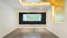 empty room, white walls, wooden floor, large window, yellow accent wall
