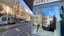 Storefront of Horcenter Horgerate, glass storefront, entrance steps, cars parked on the street