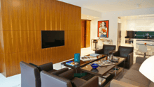 modern living room, wooden wall, flat screen TV, coffee table, armchairs, couch