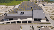 solar panels on roof, elevated building, road in front, truck present