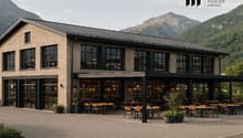 modern building, large windows, outdoor seating area, surrounded by mountains