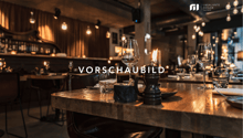 A restaurant with wooden tables and chairs, wine glasses, plates, and a candle on the table.