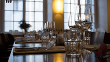 Dining table with wine glasses, water glasses, cutlery, and a flower on the table