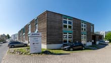 Commercial building, wood paneling, brick flooring, windows, cars parked in front