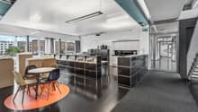modern interior design with white walls, large windows, black flooring, grey carpeting, modern seating, long tables, built-in cabinets, office equipment