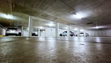 underground parking garage, number markings on ceiling, cars parked