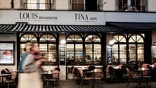 brasserie with arched windows, outdoor seating, black and white awning