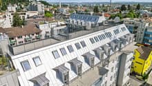 multiple story building with a terrace, windows, chimneys, a sloped roof, balconies, and city view