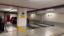 underground parking with parking spots, safety lights, and yellow and red warning stripes