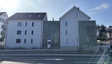 3 story building, white exterior, multiple windows, metal fence, street view