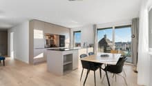 Licht, Raum und Design in Harmonie. Die hochwertige Küche mit Kochinsel verbindet sich mit dem Essbereich und wird zum Herzstück der Wohnung.