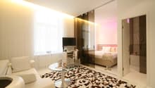 modern room with white and brown checked floor, white sofa, glass table, desk with computer, tv