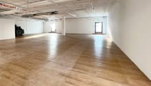 Empty room, wooden floor, bright sunlight, white walls, two glass doors, utility area