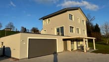 2 story house, beige exterior, large garage, brick driveway