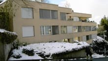 Apartment building with balcony, three floors, beige exterior, large windows, snowy surroundings