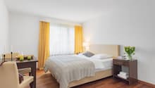 Bed, table, chair, lamp, window, nightstand, yellow curtains, flowers