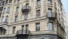 Multi-story building with ornate architectural details, including arched windows, decorative balconies, and intricate stone carvings. The building has a mix of modern and historic elements, with a Point Copy store on the ground floor.