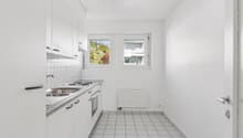 kitchen area, sink, oven, gas stove, windows, tiled floor, white cabinets