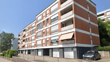 5 story apartment building, brick and white wall, balconies, car parked in front