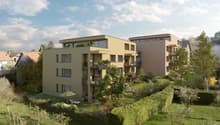 Multi-story apartment building with balconies, surrounded by a well-maintained garden with trees and landscaping.