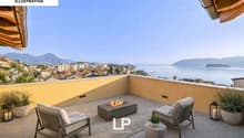 Balcony with chairs, fire pit, potted plants, lamps, rug, view of the city and sea