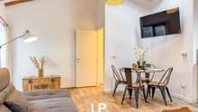 Sofa, dining table with 4 chairs, lamp, TV, wooden floor, wooden beams, wooden box with plant, rug