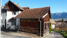 Wooden house, raised ground floor, brown roof, mountain view