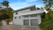 Two-story house, white exterior, two garages, balcony, staircase, driveway