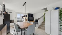 Wohnzimmer mit Kamin und grossen Fensterfronten für ein helles Ambiente