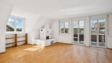 Ein Ort zum Ankommen: Heller Wohnbereich mit Balkon und behaglichem Cheminée