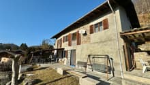 Raised ground floor house, stone walls, wooden windows, porch, garden, swing, benches