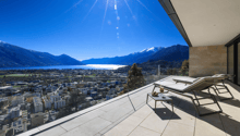Terrace with lounge chairs, table, and a view of the city and lake