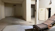 Empty room with concrete floor, white walls, two doors, and a wooden ramp.